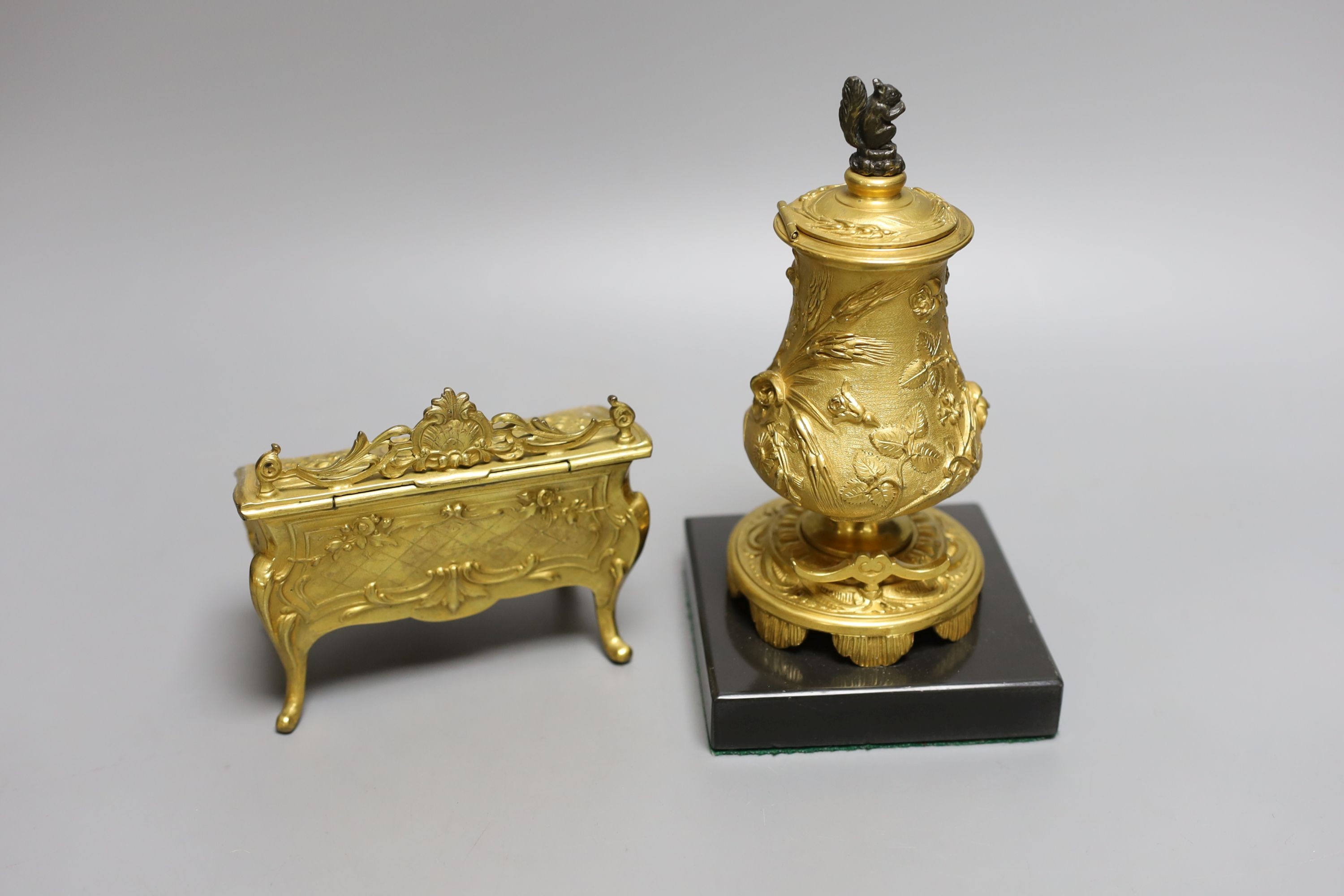 A novelty gilt metal, serpentine shaped miniature chest inkwell and a similar urn shaped inkwell, Chest 11 cms wide.